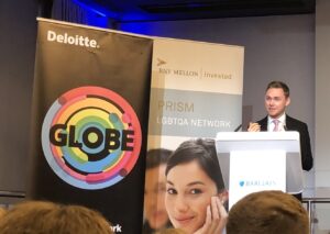 Deloitte Globe and BNY Mellon PRISM banners with speaker at Barclays podium